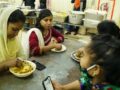 Maya Aktar eating with migrant workers.