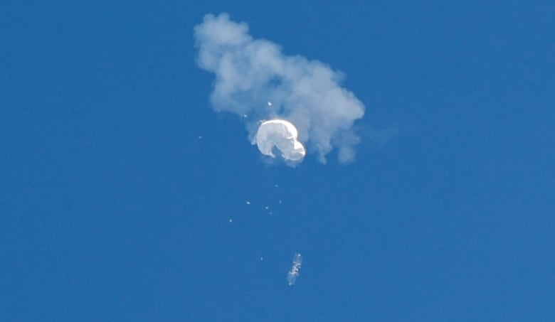 An object, suspected to be a spy balloon, is seen in the sky.
