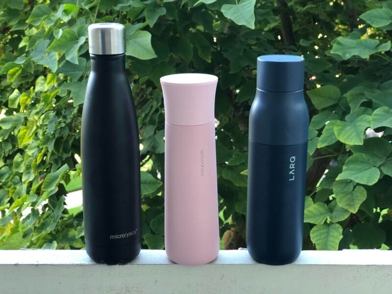 Three self-cleaning water bottles outside.