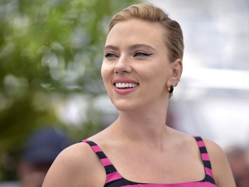 Scarlett Johansson smiling while her photo is being taken at the Cannes Film Festival.