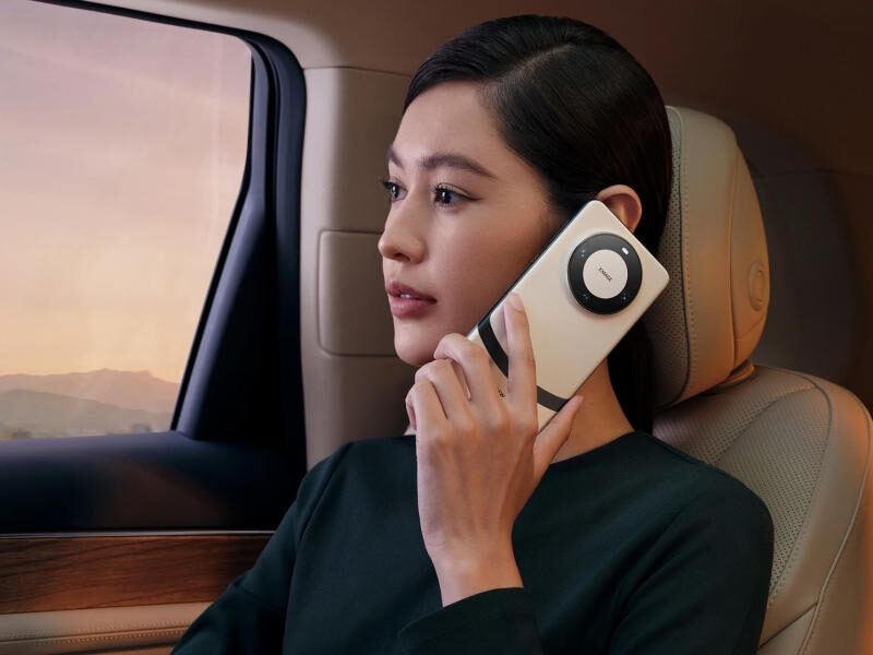 A female model posing with a Huawei Mate 60 Pro+ in a luxury car.