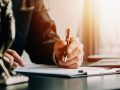 Business and lawyers discussing contract papers with brass scale on desk in office. Law, legal services, advice, justice and law concept picture with film grain effect